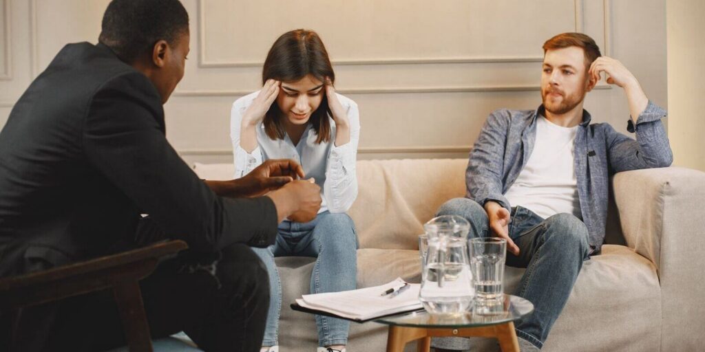 couple attending a counseling session with a therapist, discussing their issues
