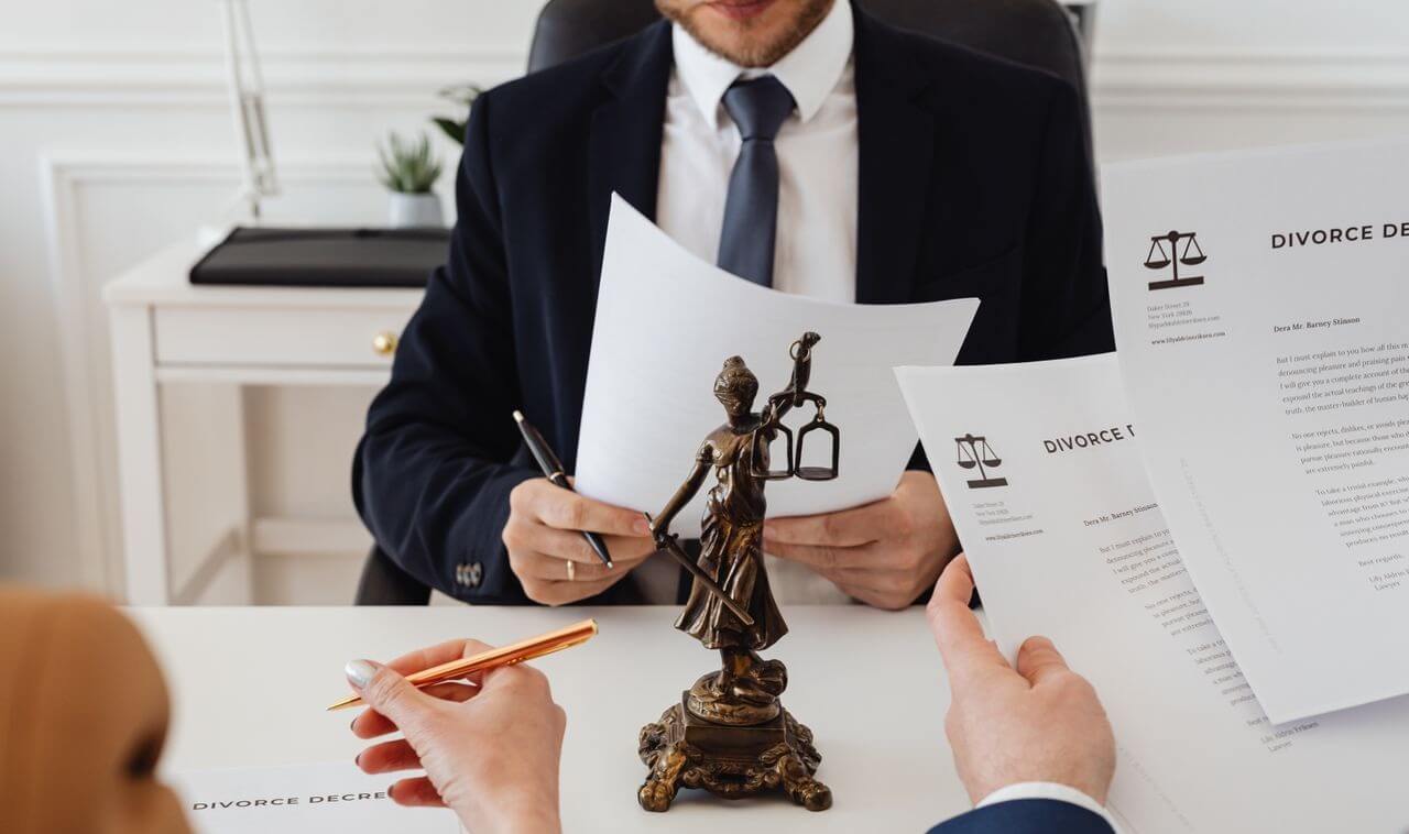 professionals reviewing divorce documents in a law office with a Lady Justice statue