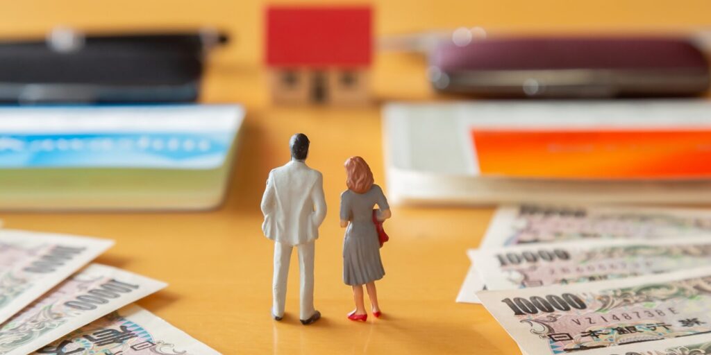 a joint mortgage two bank passbooks, a personal seal, a 10,000-yen note, and miniature figures of a man and a woman standing in front of a house